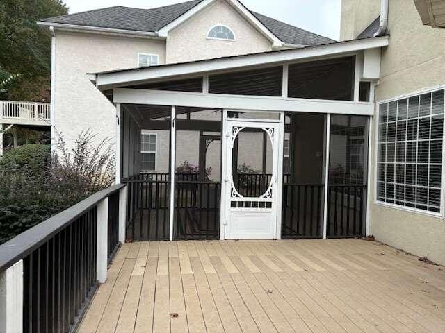 wooden deck with a sunroom