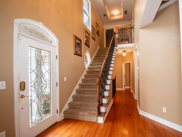 entrance foyer featuring hardwood / wood-style floors and a towering ceiling