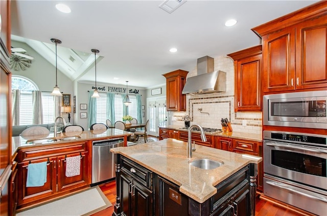 kitchen with stainless steel appliances, a warming drawer, a sink, and wall chimney exhaust hood
