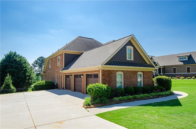 view of side of property featuring brick siding, an attached garage, a lawn, and concrete driveway