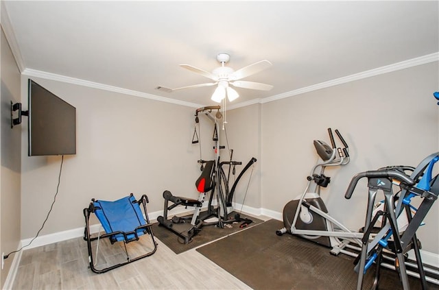 exercise room featuring baseboards, ornamental molding, ceiling fan, and visible vents
