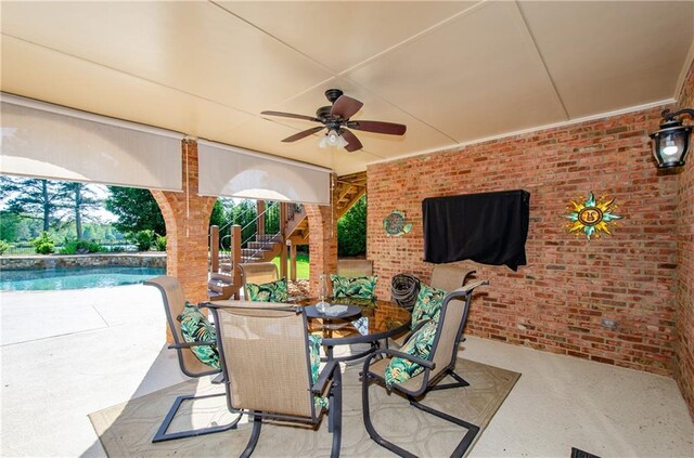 view of patio featuring stairway, a ceiling fan, outdoor dining area, and an outdoor pool