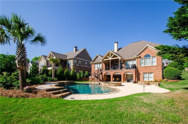 back of property featuring a lawn, stairway, brick siding, a balcony, and a patio