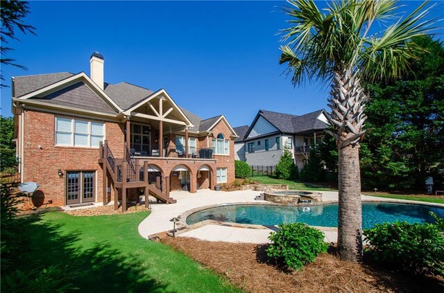 rear view of property featuring a chimney, stairs, brick siding, a patio area, and a yard