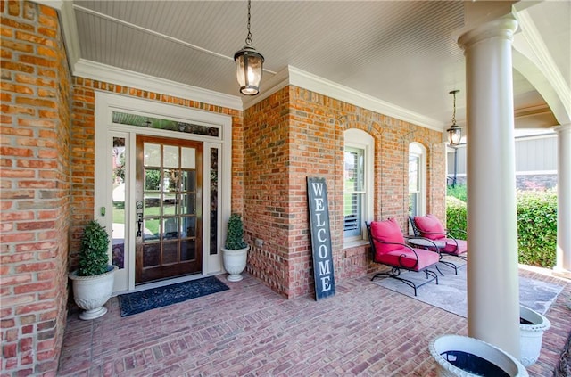 doorway to property featuring a porch and brick siding