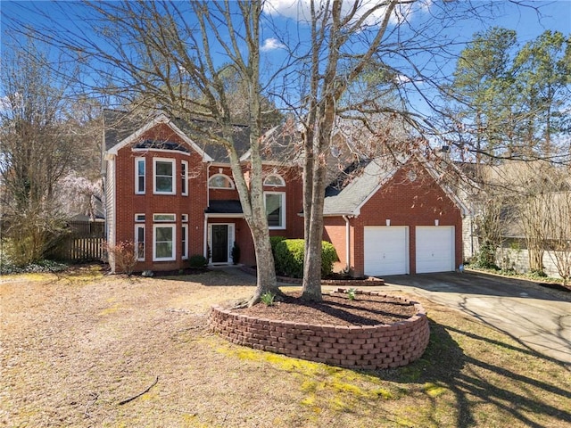 traditional home featuring a garage, fence, brick siding, and driveway