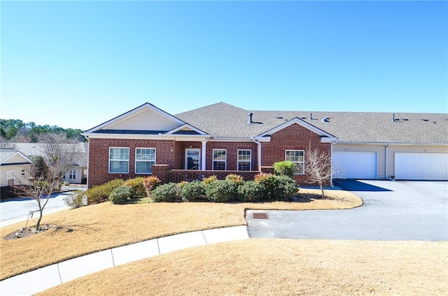 ranch-style home with aphalt driveway, a front yard, and brick siding