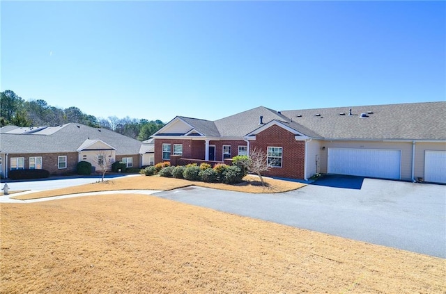 single story home with a garage, aphalt driveway, and brick siding