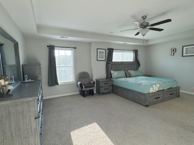 bedroom featuring a tray ceiling, ceiling fan, and carpet flooring