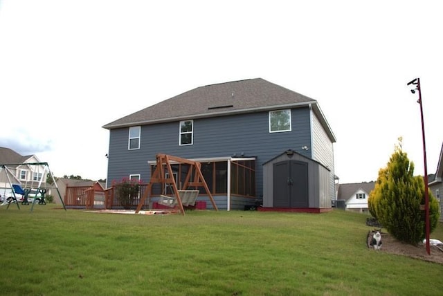 rear view of house with a lawn, a storage shed, and a wooden deck