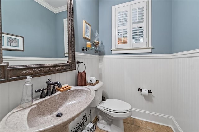 bathroom with ornamental molding, sink, and toilet