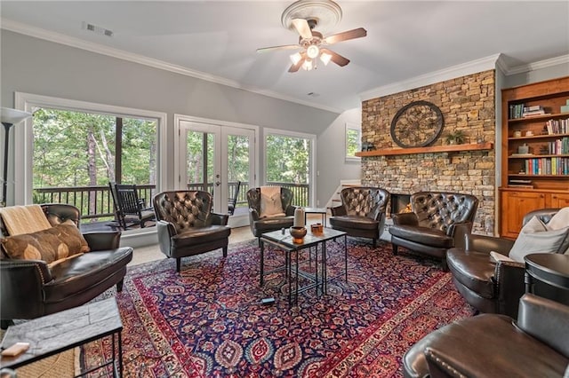 living room with crown molding, a fireplace, ceiling fan, and plenty of natural light