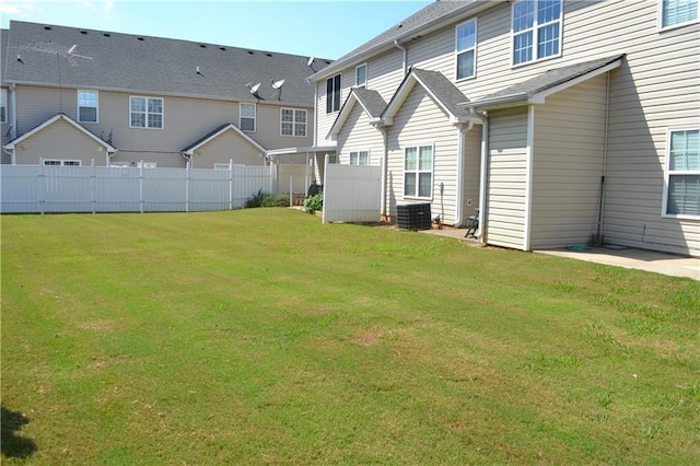 rear view of property featuring central AC unit and a lawn