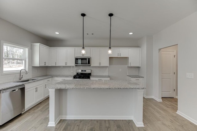 kitchen with white cabinetry, sink, a kitchen island, and stainless steel appliances