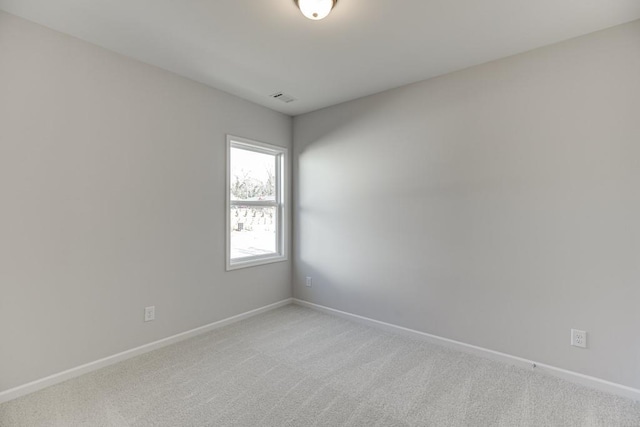 spare room featuring light carpet