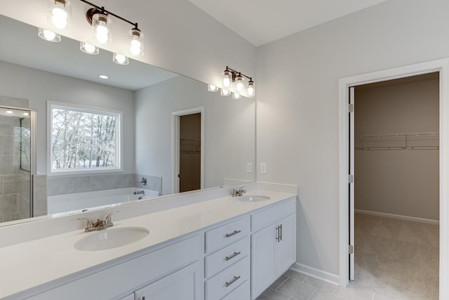 bathroom with tile patterned flooring, vanity, and a bathing tub