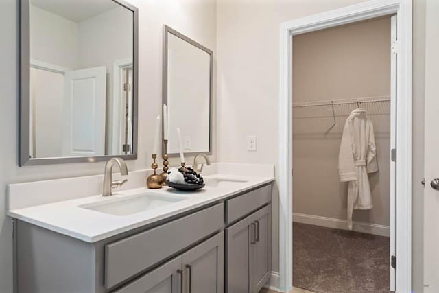 102 Sheryl Way, Loganville, GA 30052 - full bathroom with double vanity, a walk in closet, and baseboards