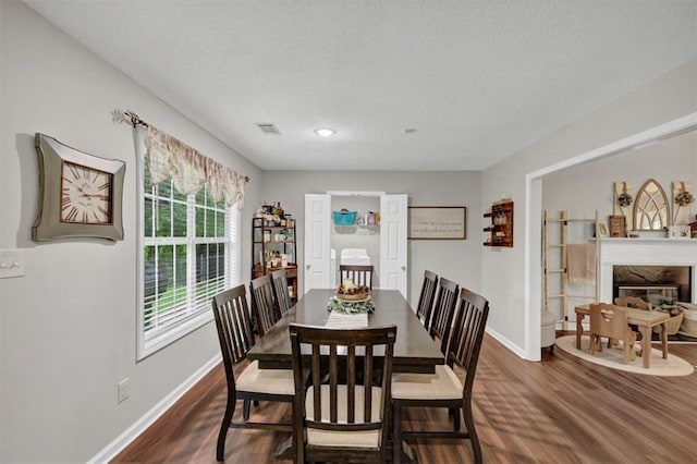 1050 Birdseye Vw, Locust Grove, GA 30248 - dining space featuring dark wood-type flooring, a textured ceiling, a high end fireplace, and recessed lighting