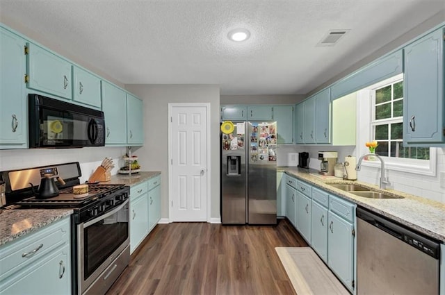 1050 Birdseye Vw, Locust Grove, GA 30248 - kitchen with stainless steel appliances, a textured ceiling, and blue cabinets
