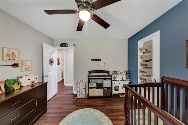 1050 Birdseye Vw, Locust Grove, GA 30248 - bedroom with dark wood finished floors, a nursery area, a ceiling fan, and a textured ceiling