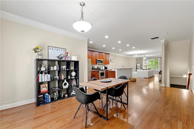 dining area featuring light wood-style floors, recessed lighting, baseboards, visible vents, and ornamental molding