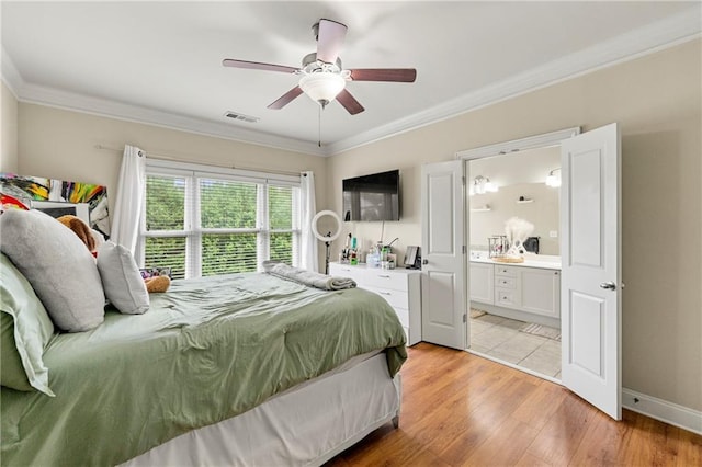 bedroom with visible vents, connected bathroom, crown molding, and light wood-type flooring