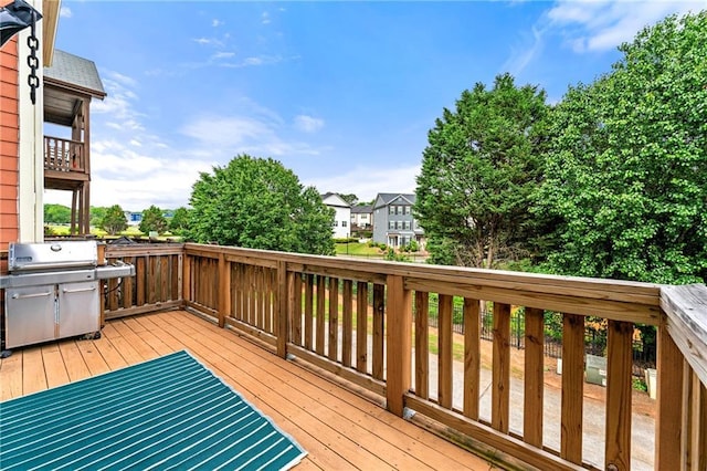 wooden deck featuring area for grilling and a residential view