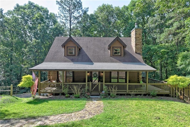 view of front of property with a porch, a front lawn, a chimney, and fence