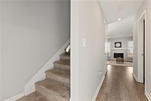 4406 Idlewood Ln, Tucker, GA 30084 - stairway with wood finished floors, a fireplace, and baseboards