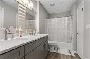 4406 Idlewood Ln, Tucker, GA 30084 - bathroom with wood finished floors, toilet, double vanity, and shower / washtub combination