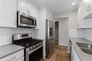 4406 Idlewood Ln, Tucker, GA 30084 - kitchen with stainless steel appliances, white cabinets, dark wood finished floors, tasteful backsplash, and recessed lighting