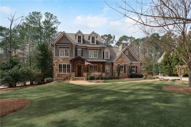 view of front of home with a front yard and stone siding