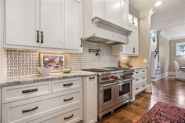 kitchen featuring range with two ovens, ornamental molding, dark wood-style flooring, custom exhaust hood, and white cabinetry