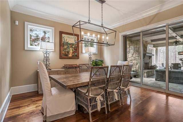 dining area featuring a healthy amount of sunlight, dark wood-style floors, baseboards, and crown molding