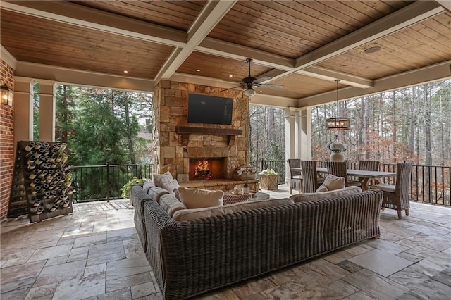 view of patio / terrace with an outdoor living space with a fireplace, outdoor dining space, and a ceiling fan