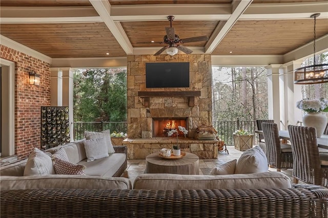 unfurnished sunroom featuring an outdoor stone fireplace, wooden ceiling, beam ceiling, and ornate columns