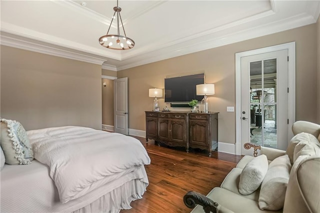 bedroom with dark wood-style floors, baseboards, a tray ceiling, and crown molding