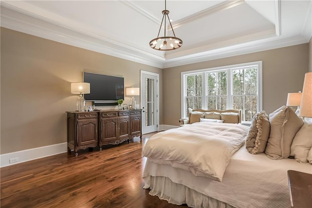 bedroom with ornamental molding, a tray ceiling, dark wood finished floors, and baseboards