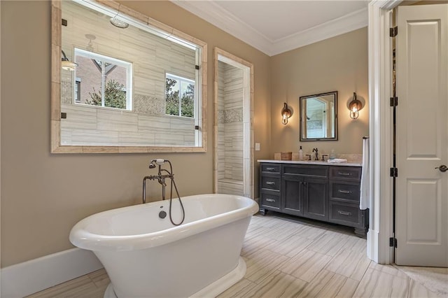 full bathroom with a freestanding tub, baseboards, ornamental molding, and vanity