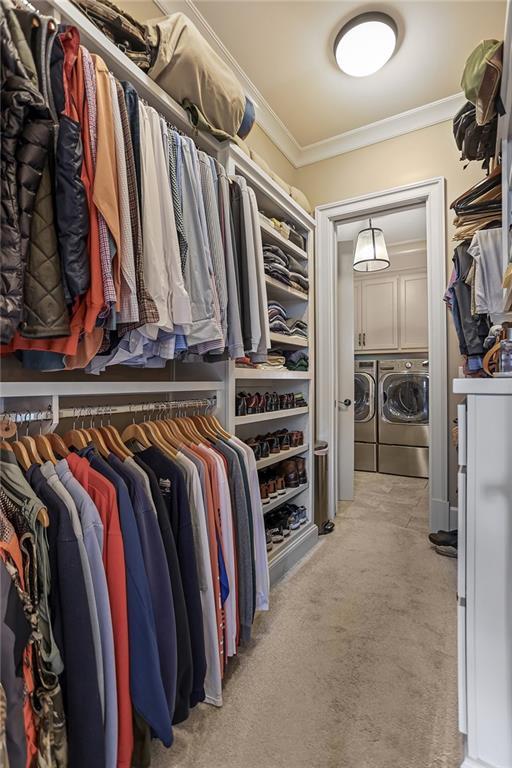 spacious closet with washer and dryer and light colored carpet