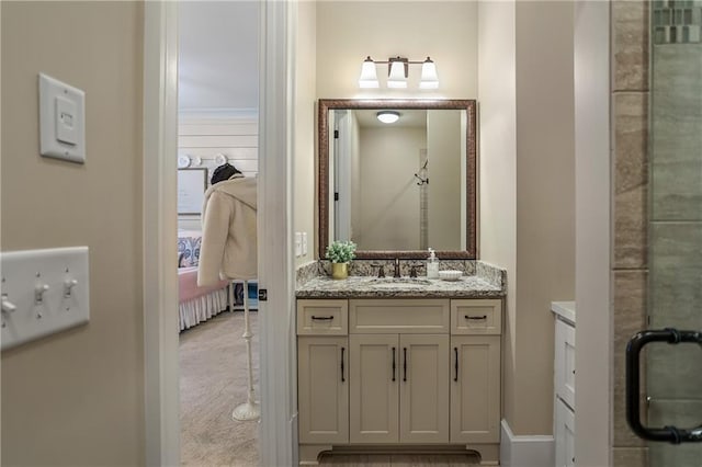 ensuite bathroom featuring a shower with shower door, vanity, and ensuite bath