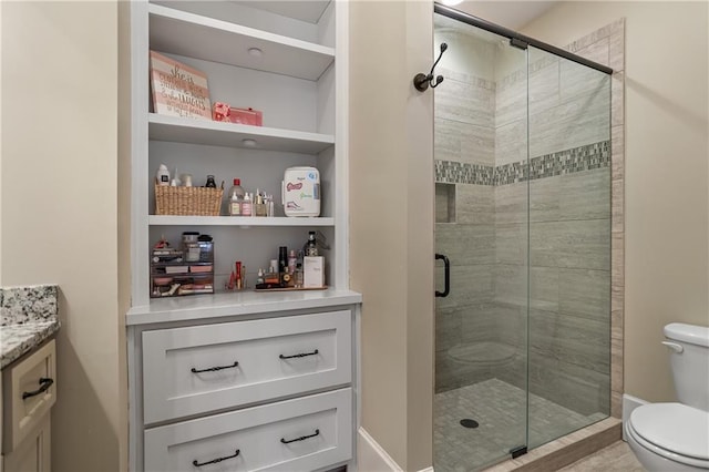 bathroom with a stall shower, vanity, and toilet