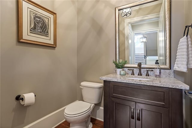 bathroom featuring vanity, toilet, and baseboards