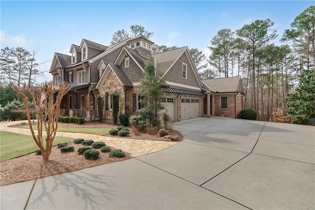 view of front of house featuring an attached garage, concrete driveway, covered porch, and stone siding