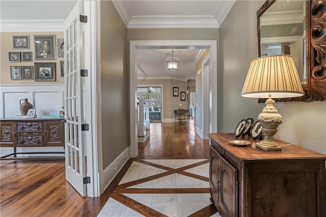 hallway featuring baseboards, french doors, wood finished floors, and ornamental molding