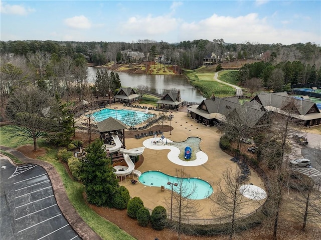 view of pool with a patio, a water slide, and a water view