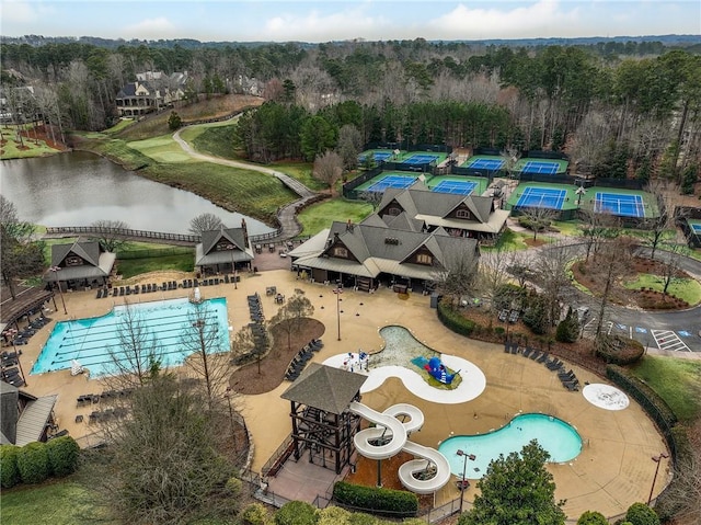 view of pool with a water view and a wooded view