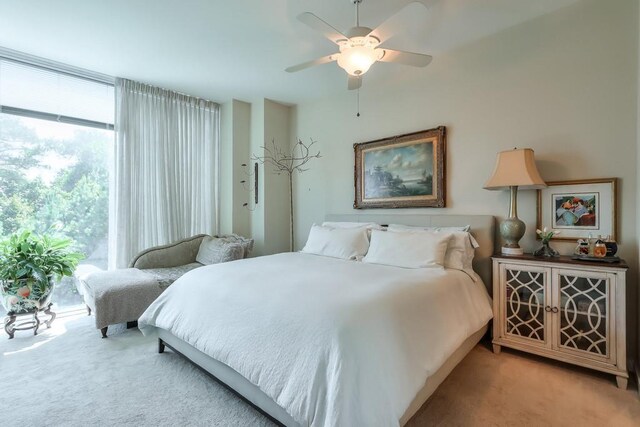 bedroom with multiple windows, light colored carpet, and ceiling fan