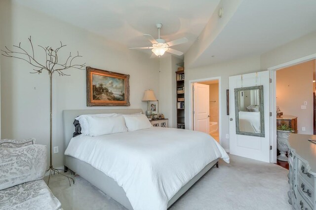 bedroom with light carpet, ensuite bathroom, and ceiling fan