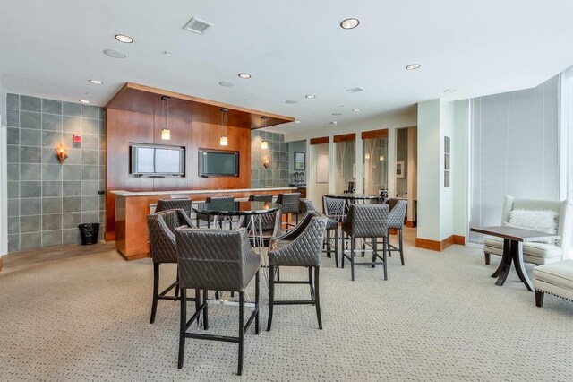 dining space with tile walls and light carpet